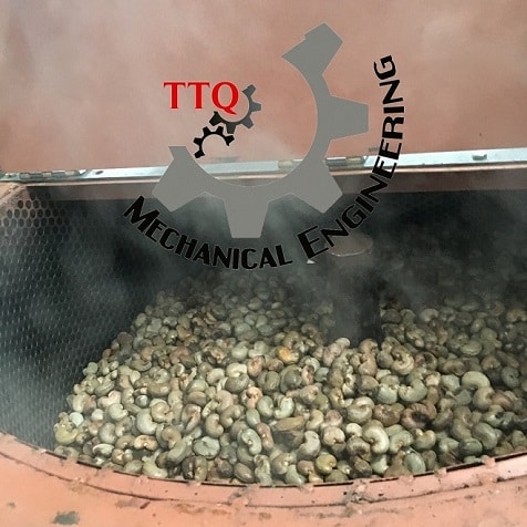 Steam rising from raw cashew nuts inside a steam conditioning machine